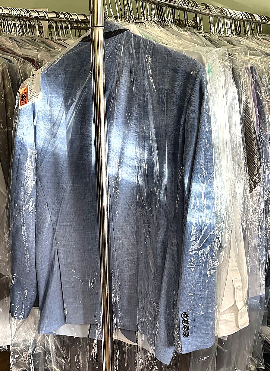 Freshly dry cleaned suit jackets and shirts bagged and ready for pickup